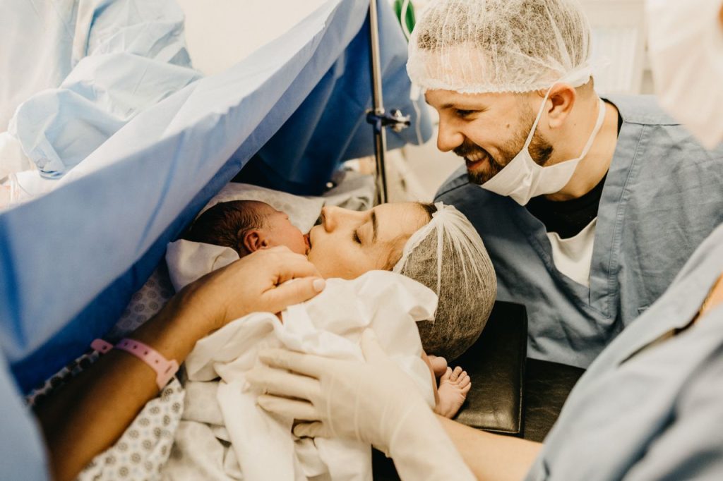 Hello world! A cherished family moment as new parents welcome their baby in a hospital delivery room.